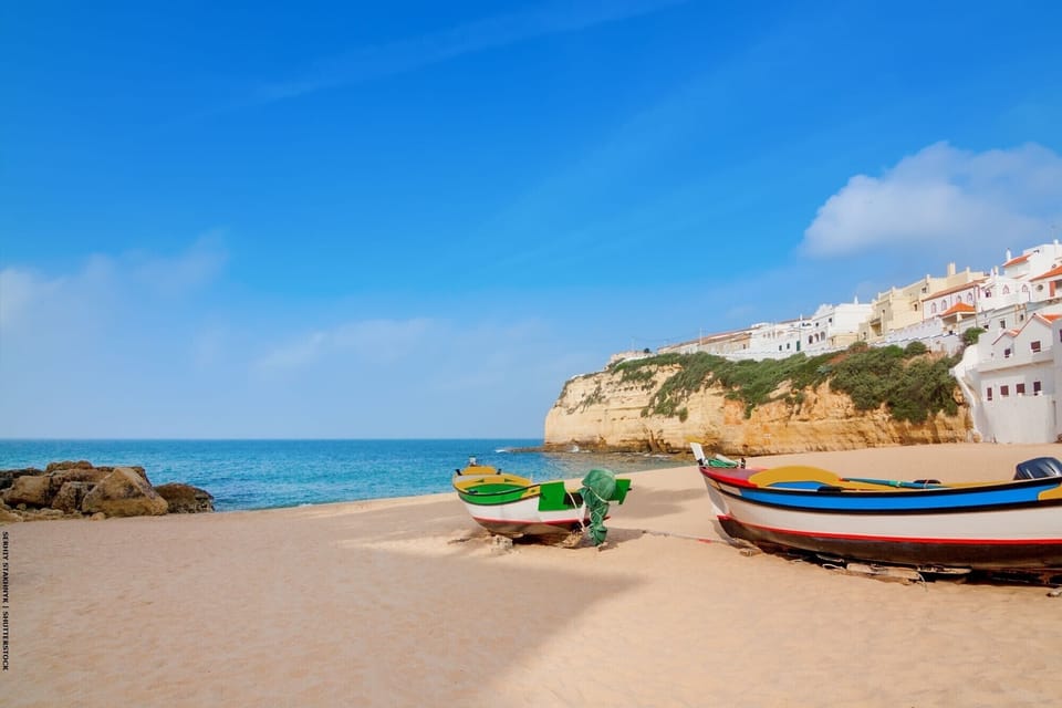 Comfortable second bedroom at Casa Sinead with a double bed, elegant sitting area with upholstered chairs, bedside table lamps, decorative area rug, and large windows allowing plenty of natural light into this welcoming Algarve holiday villa room
