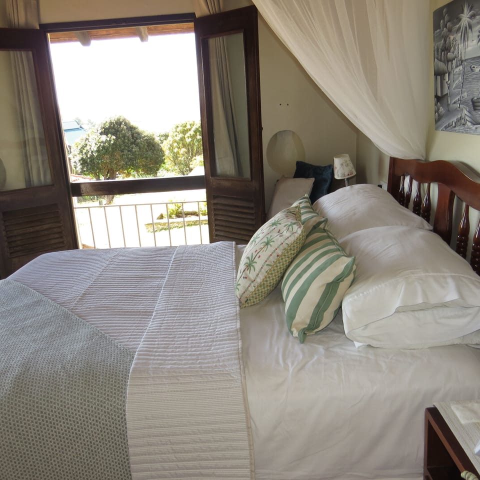 Primary suite, with queen size bed and en-suite bathroom leads out to a small patio.