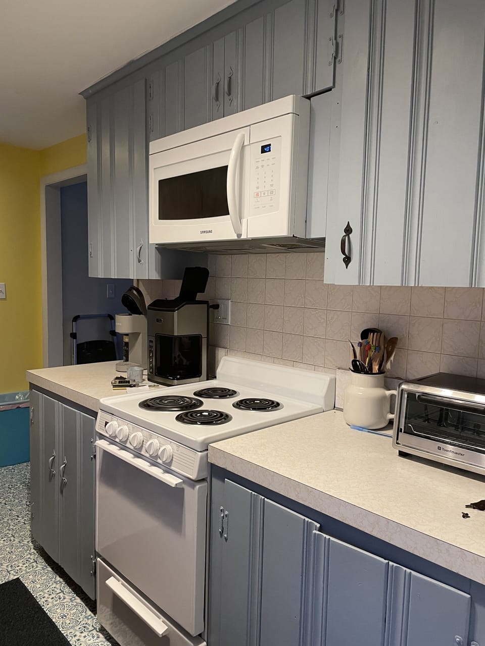 Fully stocked kitchen with toaster oven, microwave, coffee maker, blender