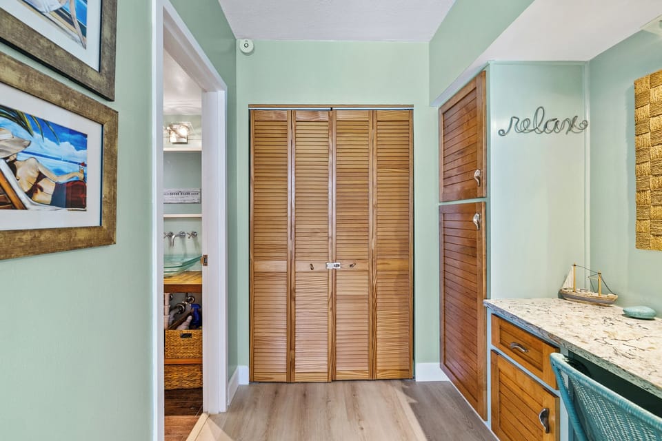 Primary bedroom vanity, closet, and entrance to the bathroom.