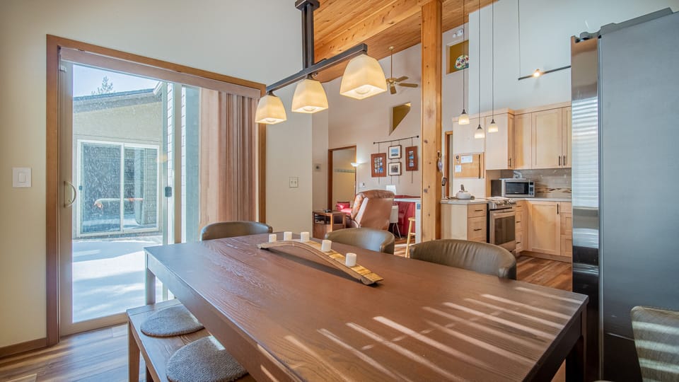 Gather around your spacious dining table where sunlight streams through large windows, creating the perfect spot for memorable meals together.