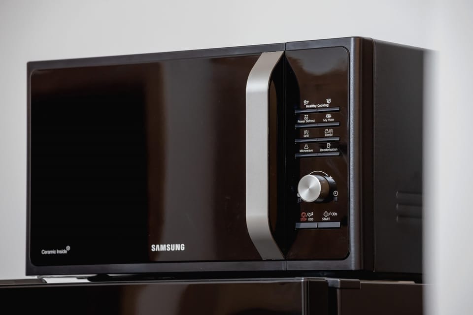 A close-up of a black microwave oven, adding to the kitchen's functional and contemporary style.
