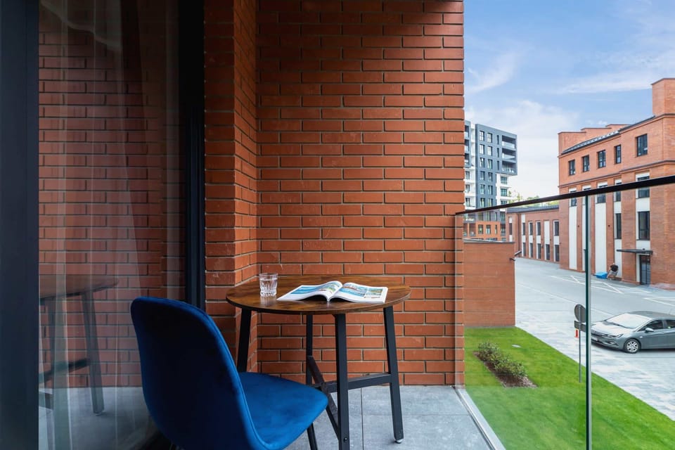 A private balcony with outdoor seating and a view of the urban setting, perfect for a morning coffee.
