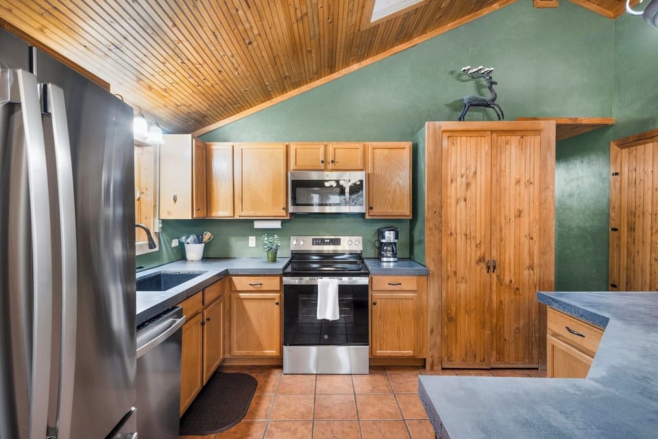Fully equipped kitchen stainless steel appliances and concrete countertops.