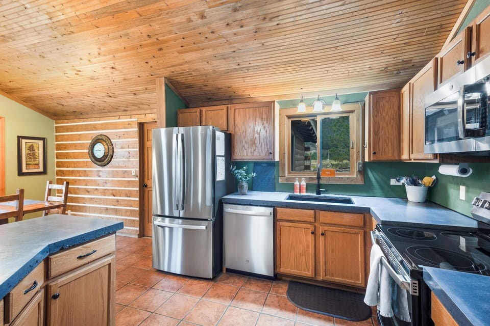 Fully equipped kitchen stainless steel appliances and concrete countertops.
