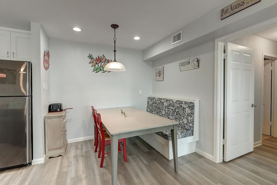 Your bright dining nook features cheerful red chairs and quirky wall art, perfect for morning coffee or intimate meals together.