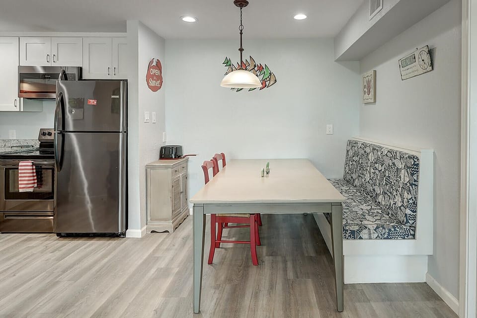 Your modern kitchen flows into a cozy dining nook where morning coffee and evening meals become memorable moments together.