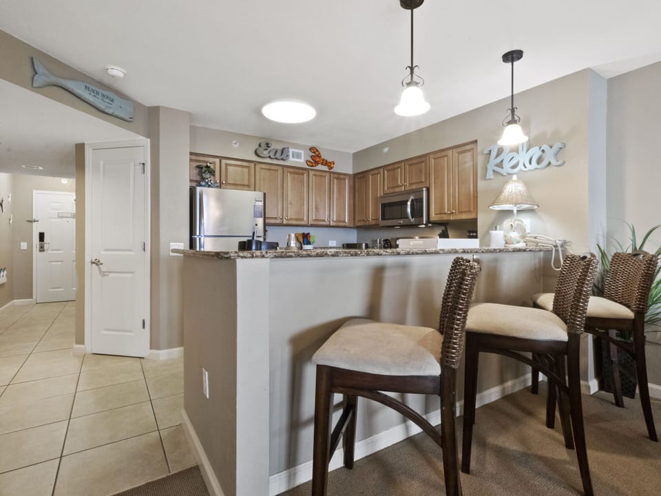 Your spacious kitchen awaits with granite counters, stainless appliances, and a breakfast bar perfect for casual meals and morning coffee.