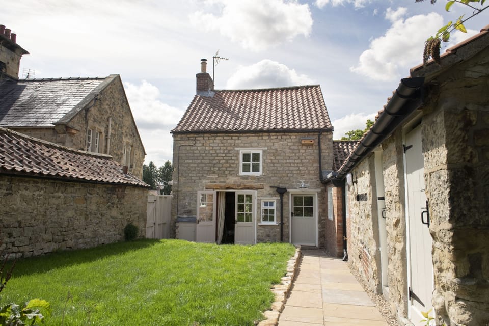 Beau Repaire, Yorkshire: Pretty garden mostly laid to lawn with garden furniture and a charcoal barbecue