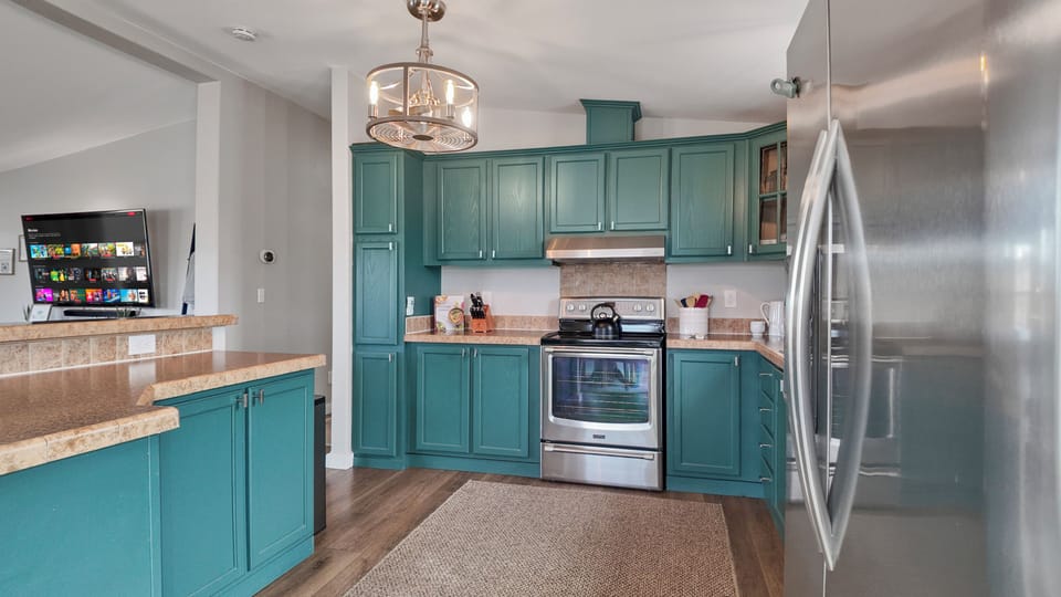 Chef’s kitchen with emerald cabinets