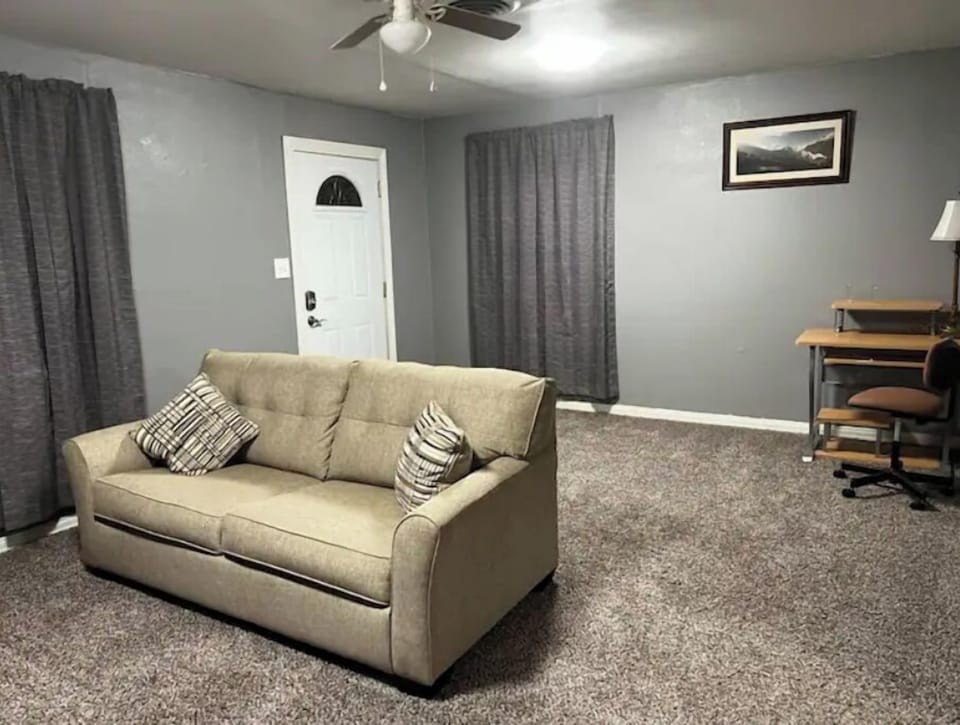 Living room with sofa bed, work station and printer.