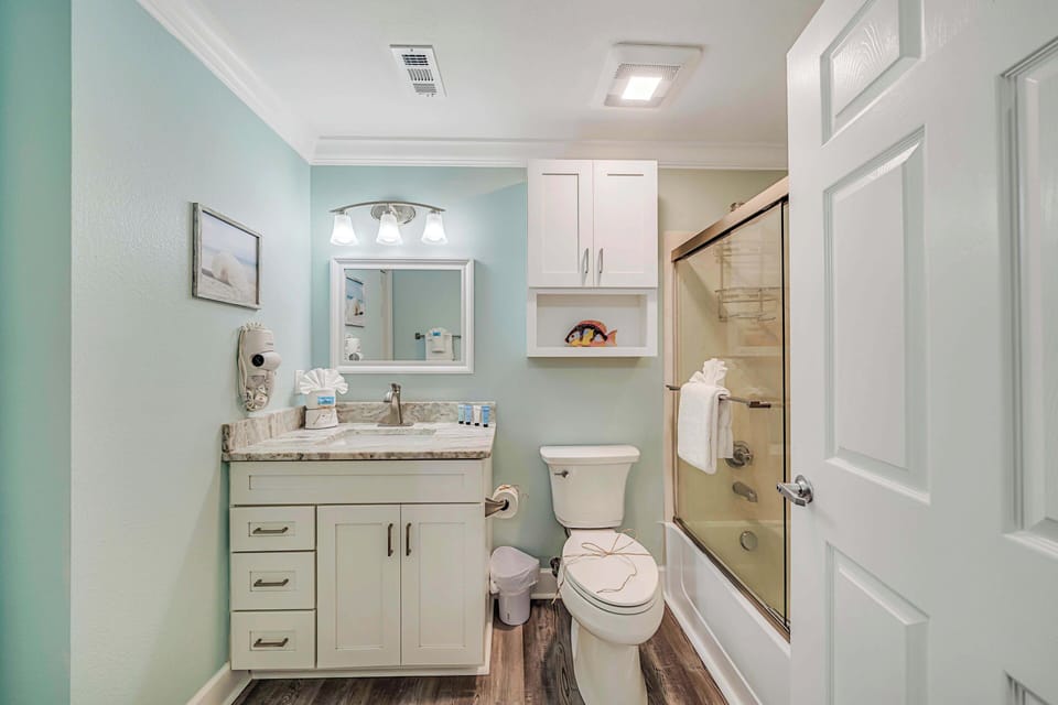 The ensuite bathroom features granite countertops and a tub/shower combo with glass tub enclosure.