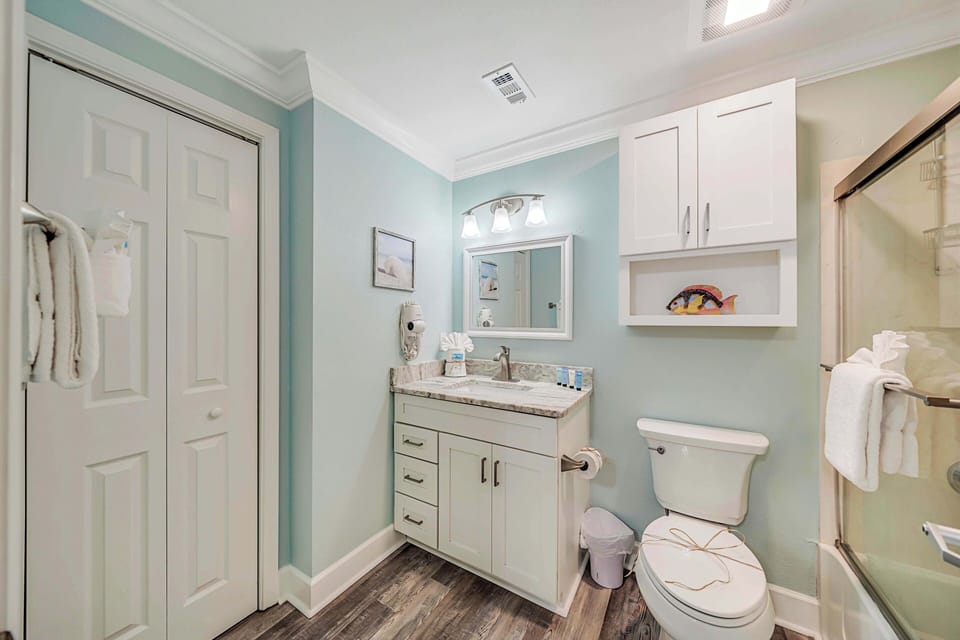 The ensuite bathroom features granite countertops and a tub/shower combo with glass tub enclosure.