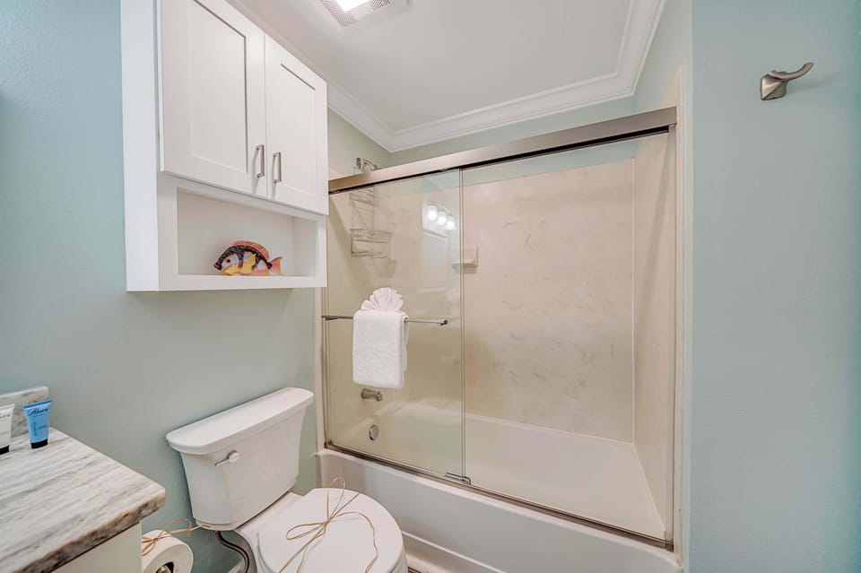 The ensuite bathroom features granite countertops and a tub/shower combo with glass tub enclosure.