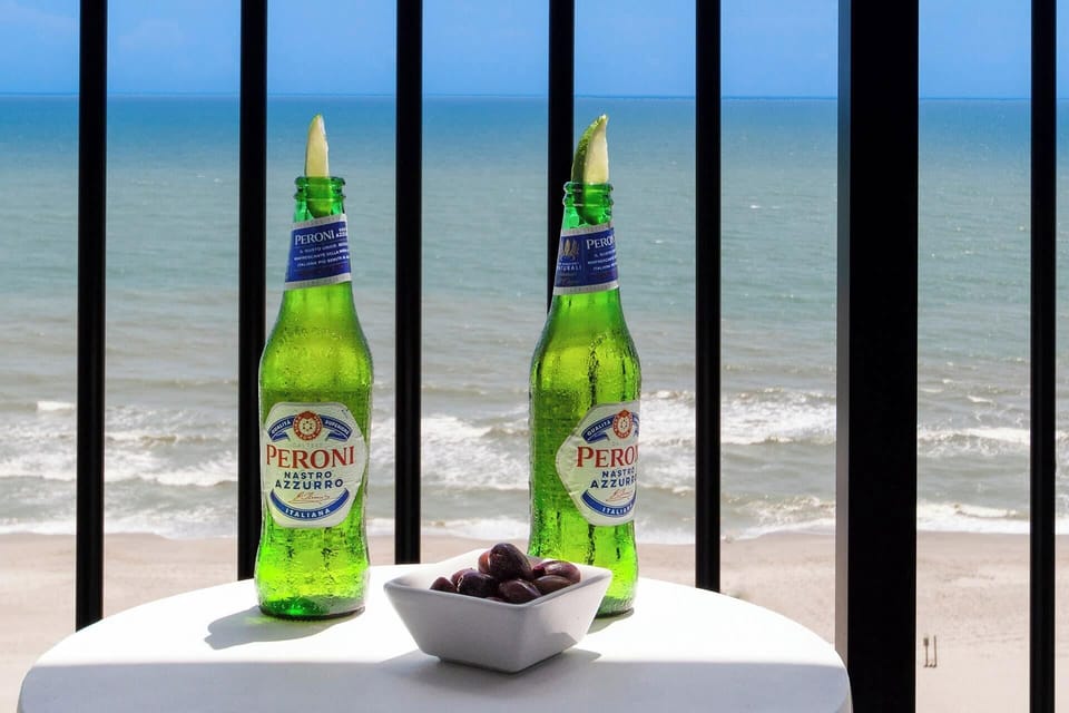 Enjoy a refreshing Peroni with a side of olives on your balcony, overlooking the waves. The perfect setting to unwind, sip, and savor the tranquil seaside ambiance, turning a simple moment into a memorable escape.