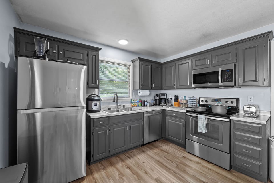 Fully equipped kitchen with blender, kettle, Instant Pot, toaster, and cookware.