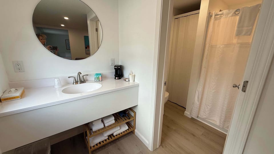 Bathroom with toilet and shower. Sink/vanity on main area.