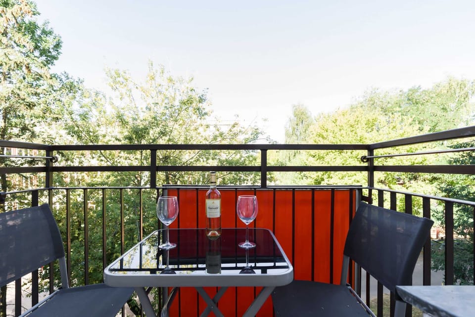A balcony with a dining setup, offering outdoor seating surrounded by greenery, perfect for morning coffee or evening relaxation.
