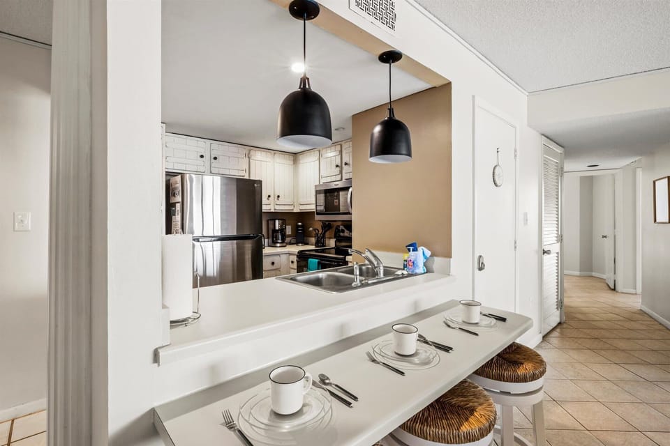 The kitchen includes plenty of counter space and a breakfast bar with seating—ideal for quick meals or casual conversations.