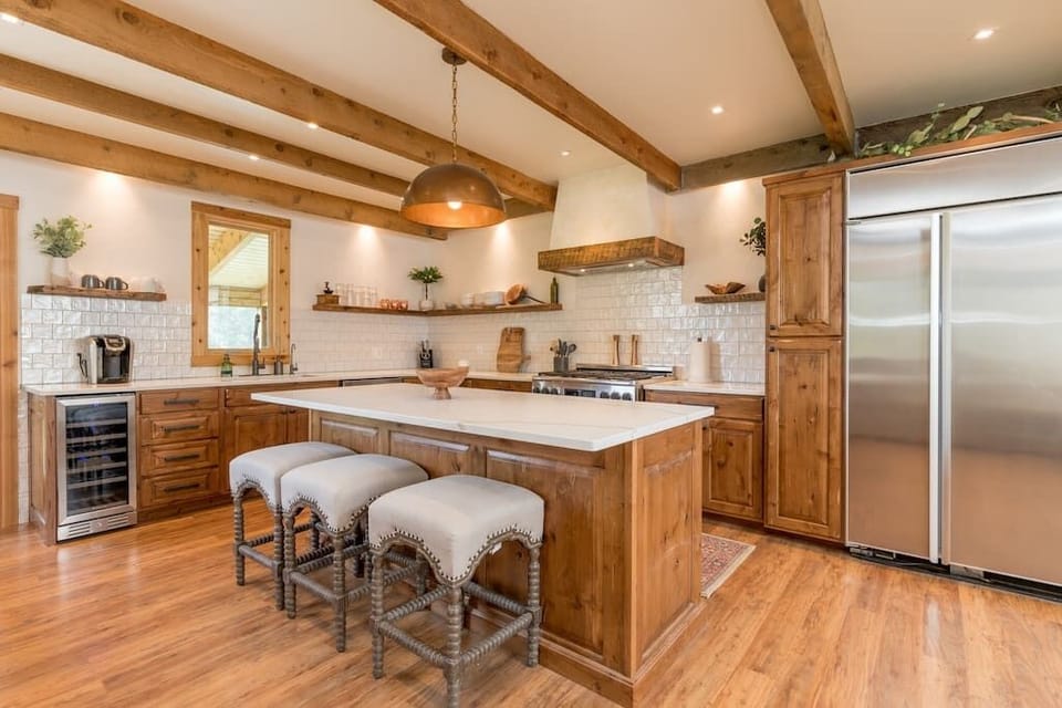 Chef's kitchen with 36" gas range, large island with seating and wine fridge. 
