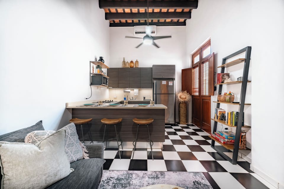 View from the living area into the full kitchen, with peninsula bar seating.