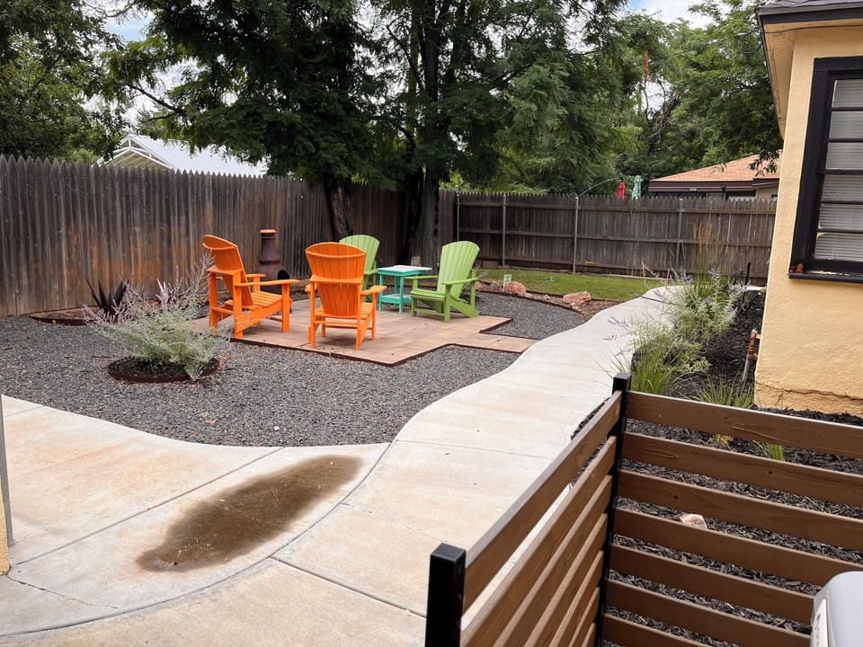 securely fenced back yard with sitting space and fire 
