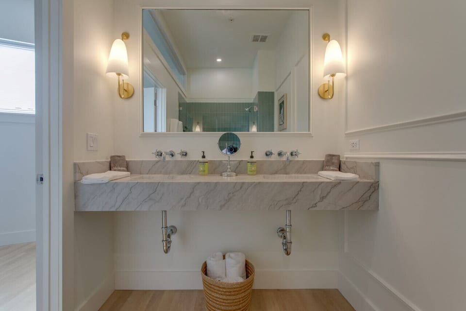 Renovated full size bathroom with two sinks.