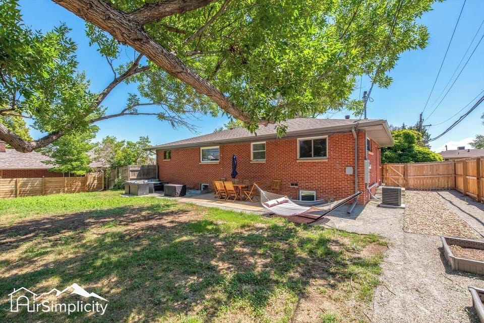 - Spacious fenced backyard with mature trees and open grassy areas for play
- Relax in the hammock or dine at the shaded patio set under the umbrella
- Red brick exterior adds charm to this private outdoor escape