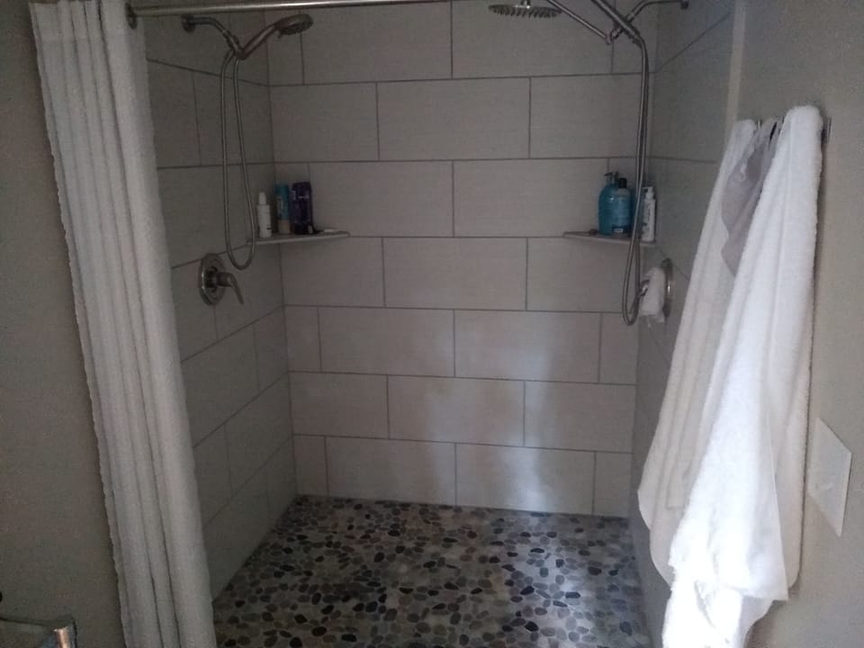 Adjacent to the upper bedroom is a double head shower.
