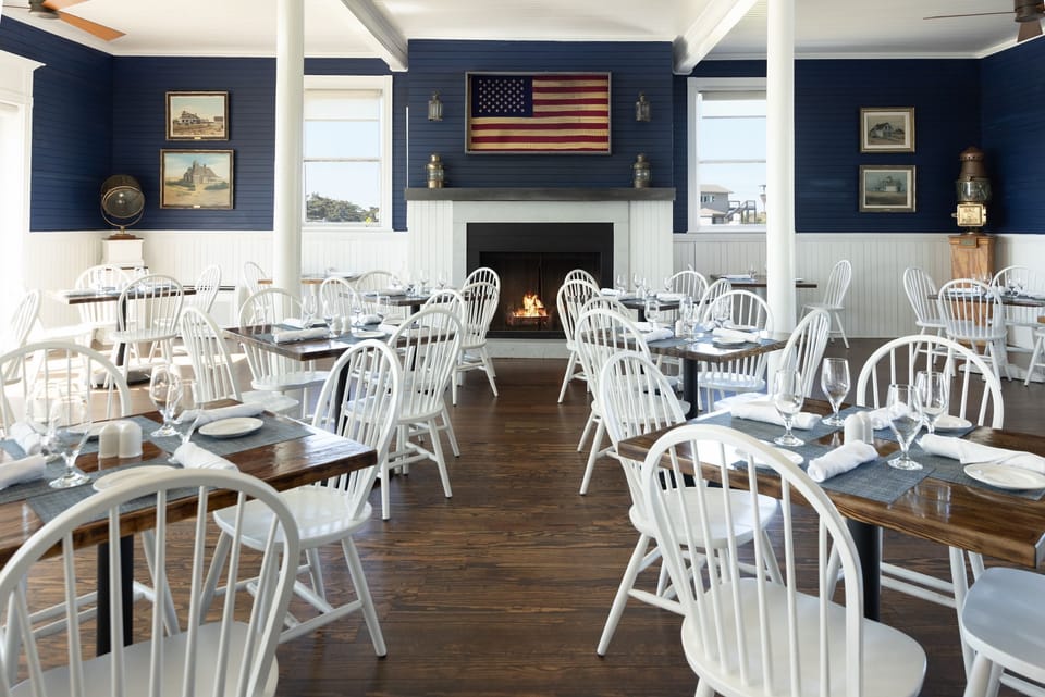 Waterfront dining with a fireplace and coastal decor — reserve a table at Theodosia