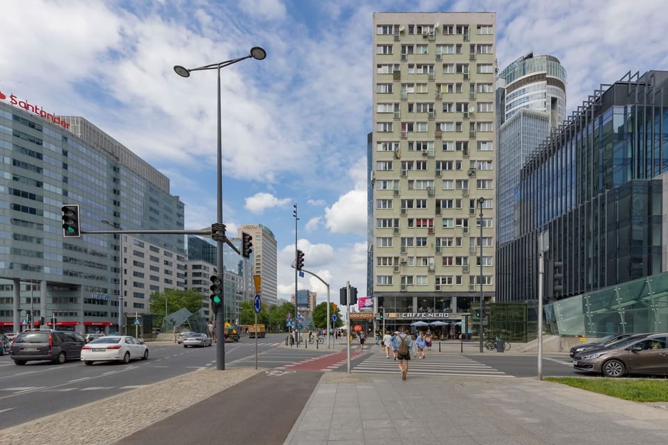 A street-level view of the urban surroundings, showcasing modern skyscrapers and vibrant city life.
