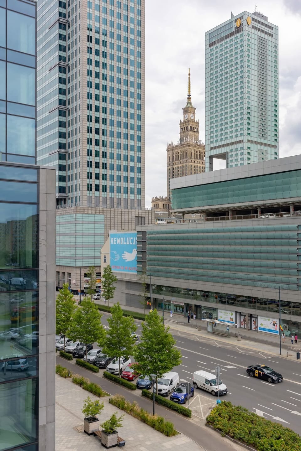 A view of the iconic Palace of Culture and Science surrounded by contemporary architecture.

