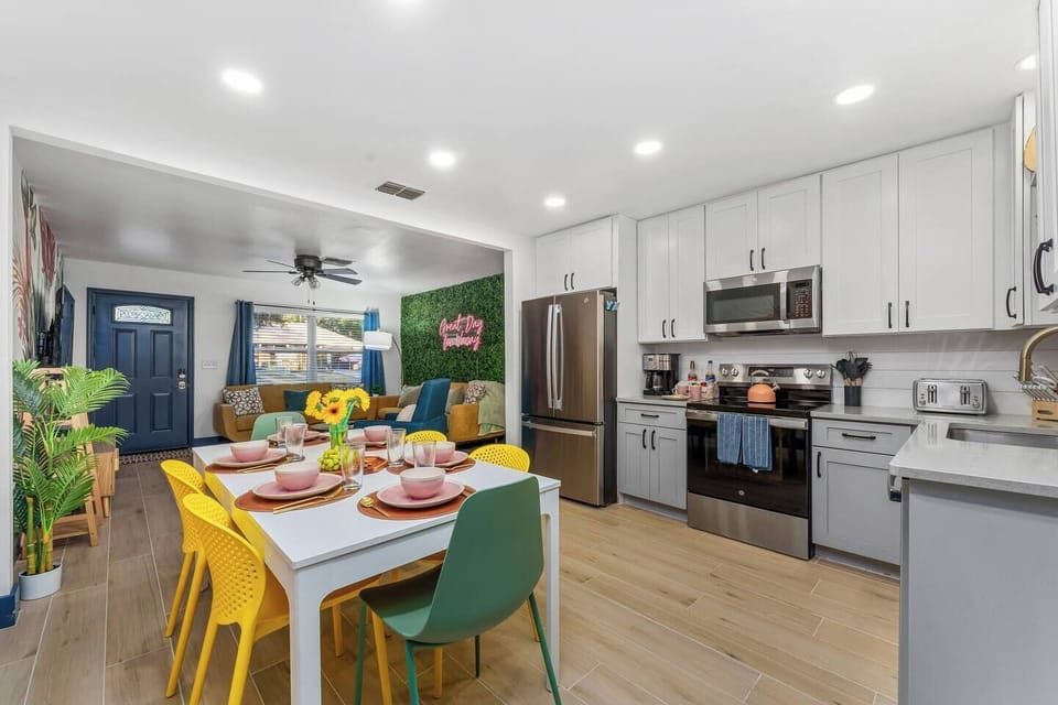 A cozy dining area and kitchen with high-end appliances, Dining Table that can seat up to 8 and a warm color contrast, creating an inviting and comfortable space.