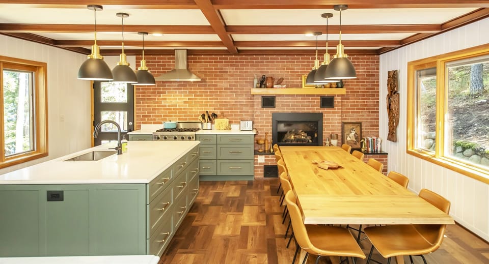 Chef's kitchen features large dining table and fireplace.