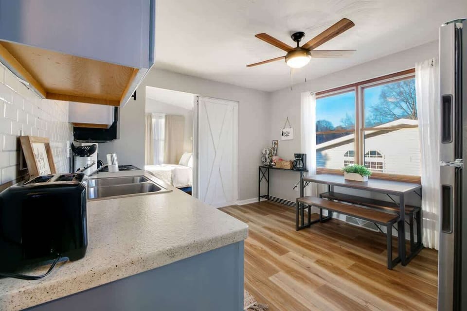 - Kitchen with open layout and natural lighting   - Wooden dining bench for meals or work space   - Easy access to bedroom and living areas  