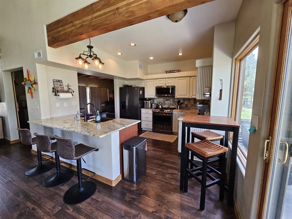 Kitchen island w/ 3 bar stools. The breakfast table lets you take in the view.