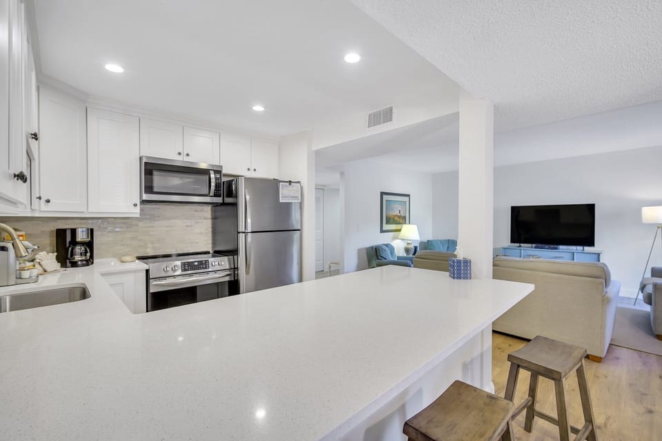 Newly remodeled with stainless steel appliances and peninsula with barstools.