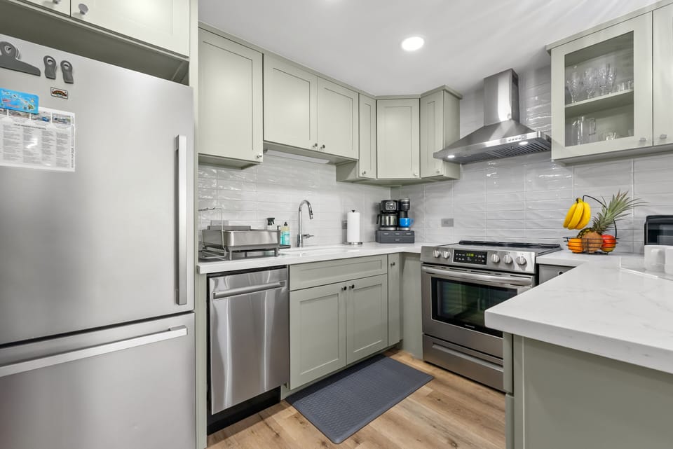 Modern kitchen with quartz countertops & stainless steel appliances.