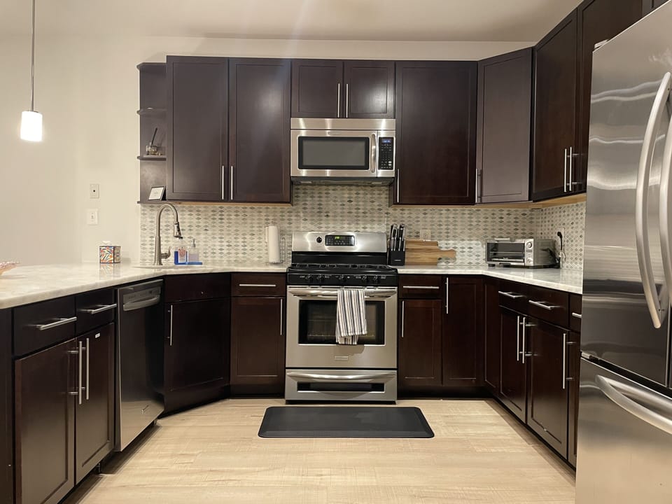 Large, fully stocked kitchen with marble countertops and gas range