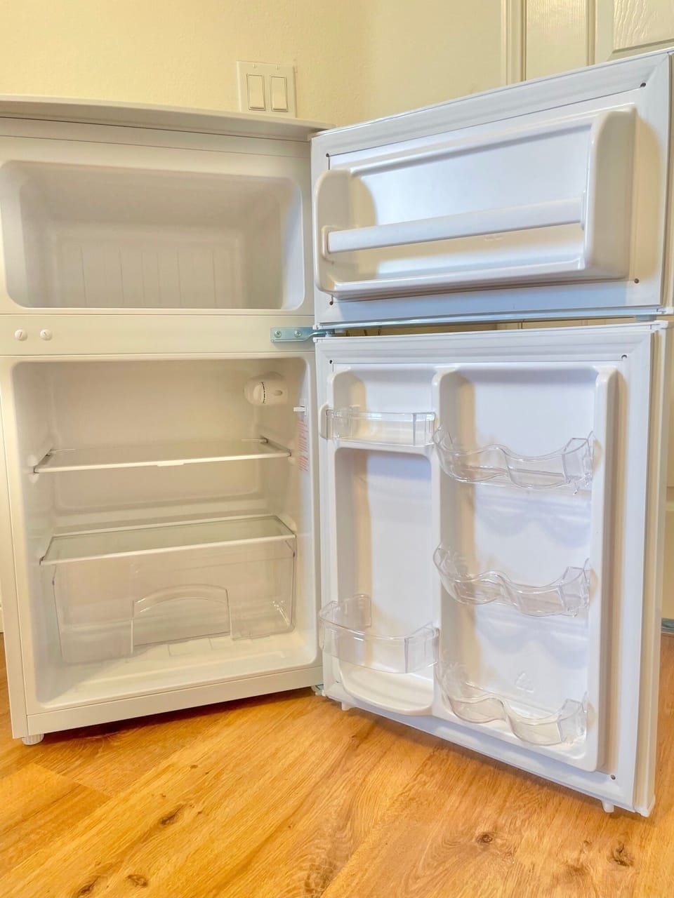 Mini fridge and freezer with ice cube trays.