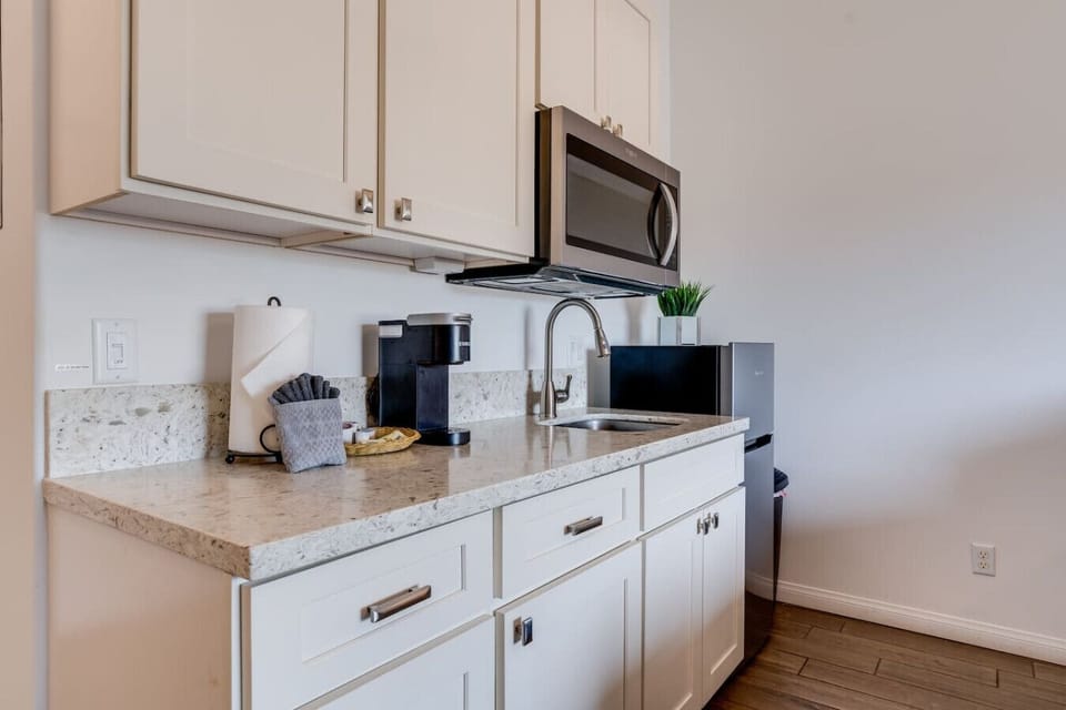 Kitchenette equipped with essential tools for preparing small meals. There is no stove or oven, but it includes a portable hot plate, skillet, and other basic cookware