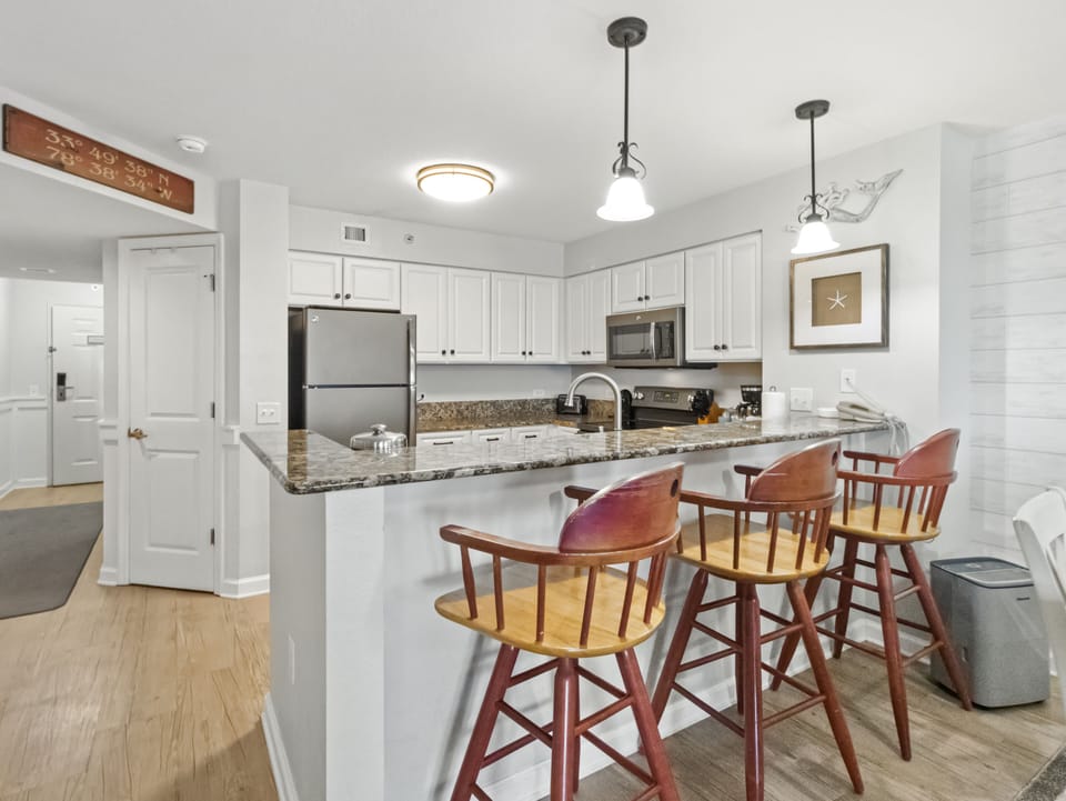 Your spacious kitchen features granite counters, stainless appliances, and a breakfast bar perfect for morning coffee or casual meals.