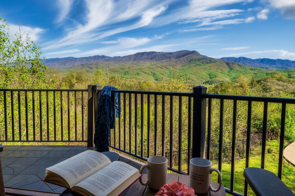 Morning coffee and a good book with the Smoky Mountains stretching before you — this is what a day at Birdsong Ridge looks like before it even begins. The upper balcony puts you face to face with one of the most unobstructed panoramic views in the Smokies.