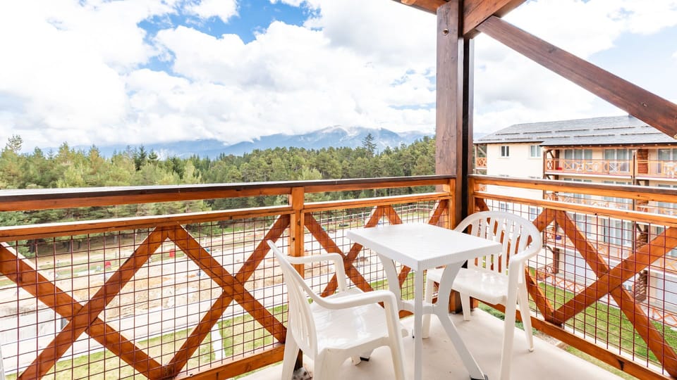 Relax on the private balcony with outdoor seating, offering beautiful views of the surrounding landscape.
