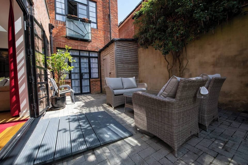 Outdoor Lounge: Relax in this sunlit patio with stylish seating and charming greenery!