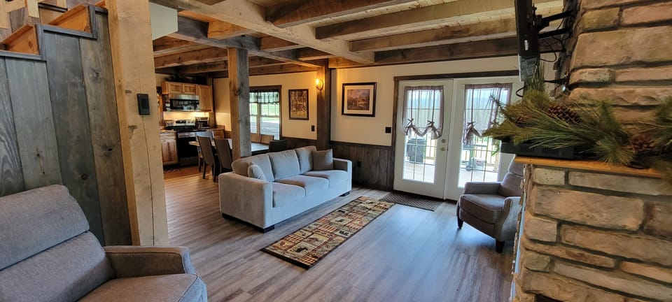 Spacious and cozy living room with doors to deck with couch and chair.
