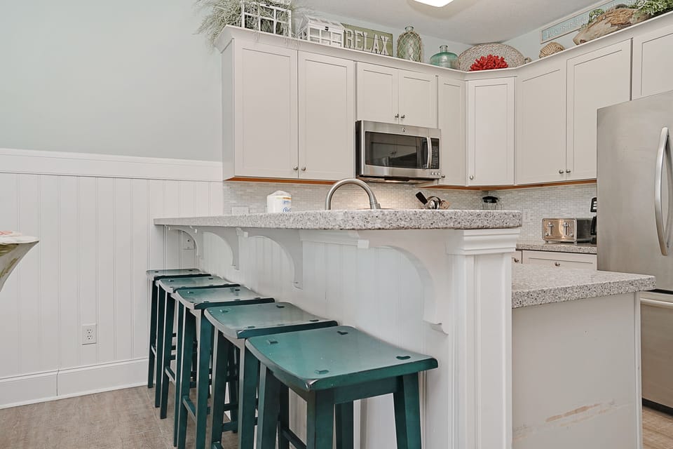 Your fully equipped kitchen awaits with granite countertops, stainless appliances, and charming coastal touches for memorable meal prep together.