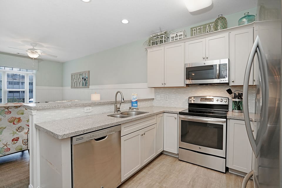 Cook your favorite meals in this fully equipped kitchen with granite counters, stainless appliances, and charming coastal decor.