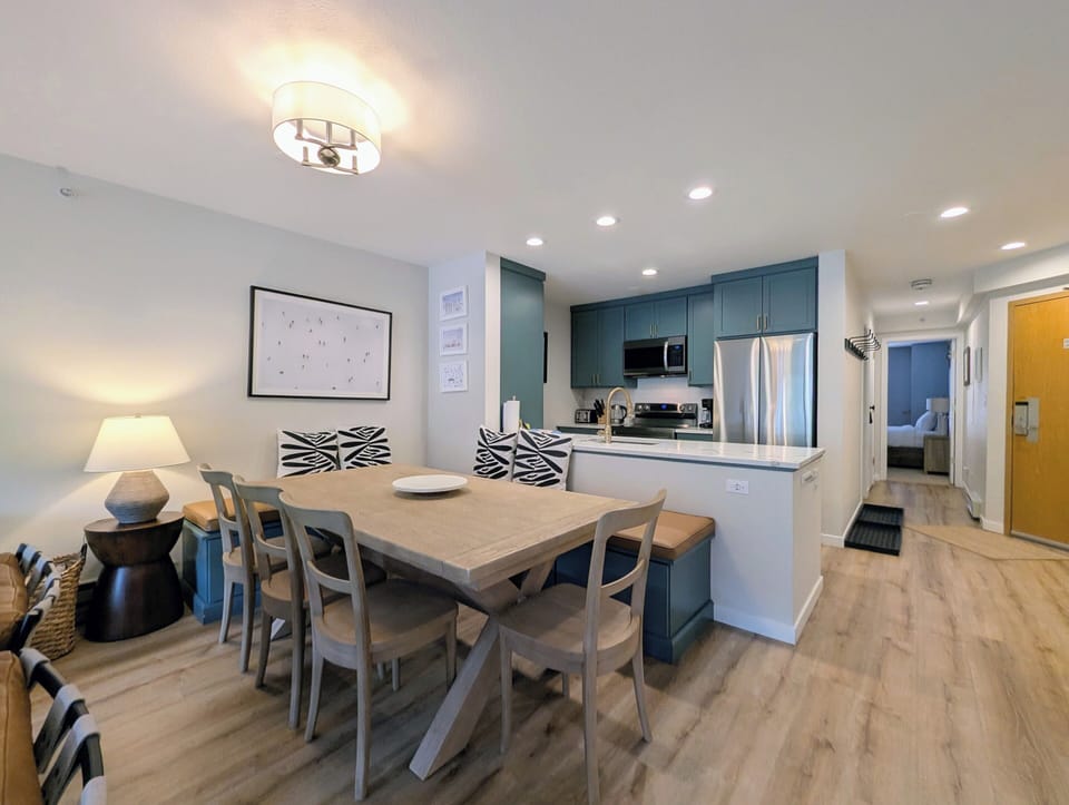 Gather around your spacious dining table with modern kitchen just steps away—complete with stainless appliances and coastal-inspired cabinetry perfect for preparing your favorite meals together.