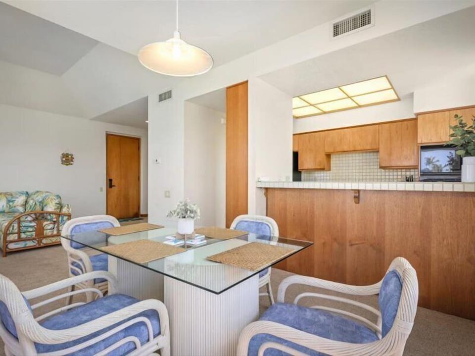 Step into your open-concept retreat where warm wood tones and coastal charm create a relaxing home base for your vacation. The full kitchen and spacious dining area invite leisurely meals together.